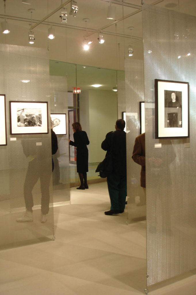 Photograph of the Humanities Gallery with visitors viewing framed artwork on the walls