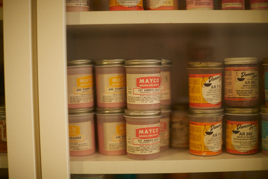 Colorful jars of glaze in Kathy Butterly's studio