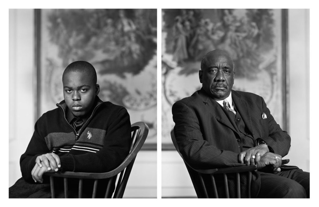 Two black and white portraits presented side by side. On the left, a Black teen boy in a pullover jacket, on the right, an older man in a suit. Both sit in chairs and look at the camera head-on with strong, steady, unshakeable expressions.